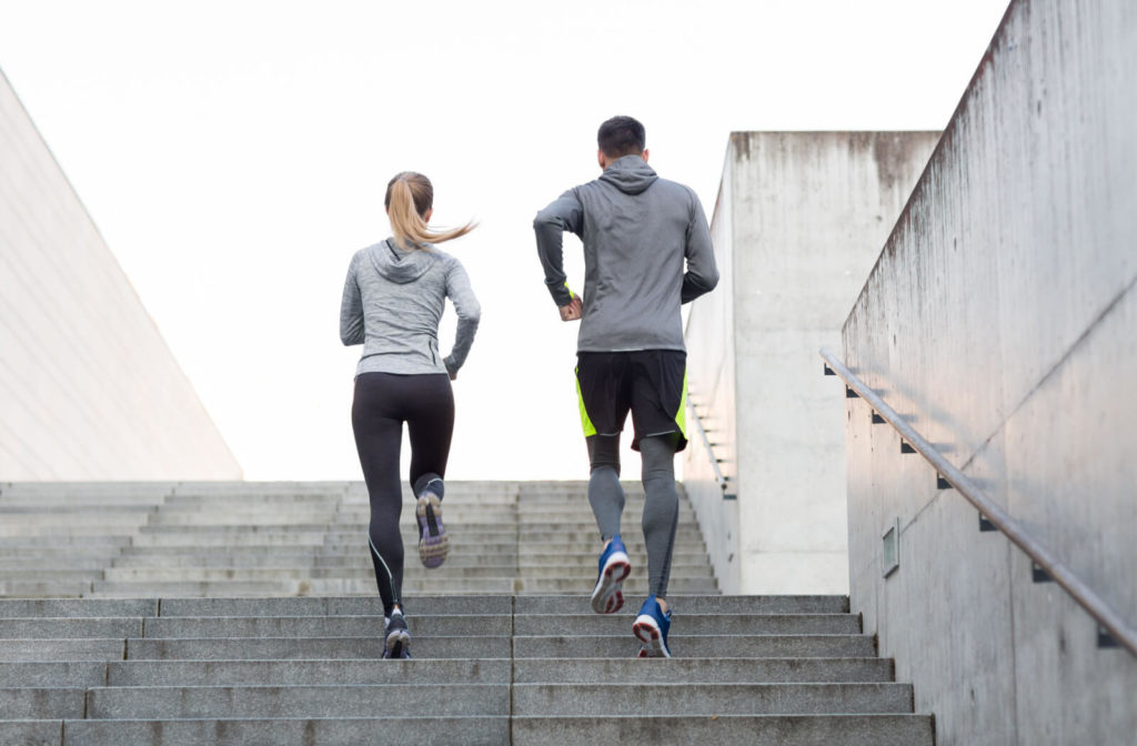 A young couple running upstairs on city stairs. Many seniors struggle to maintain their balance as they age, and stairs account for more than half of all falls.