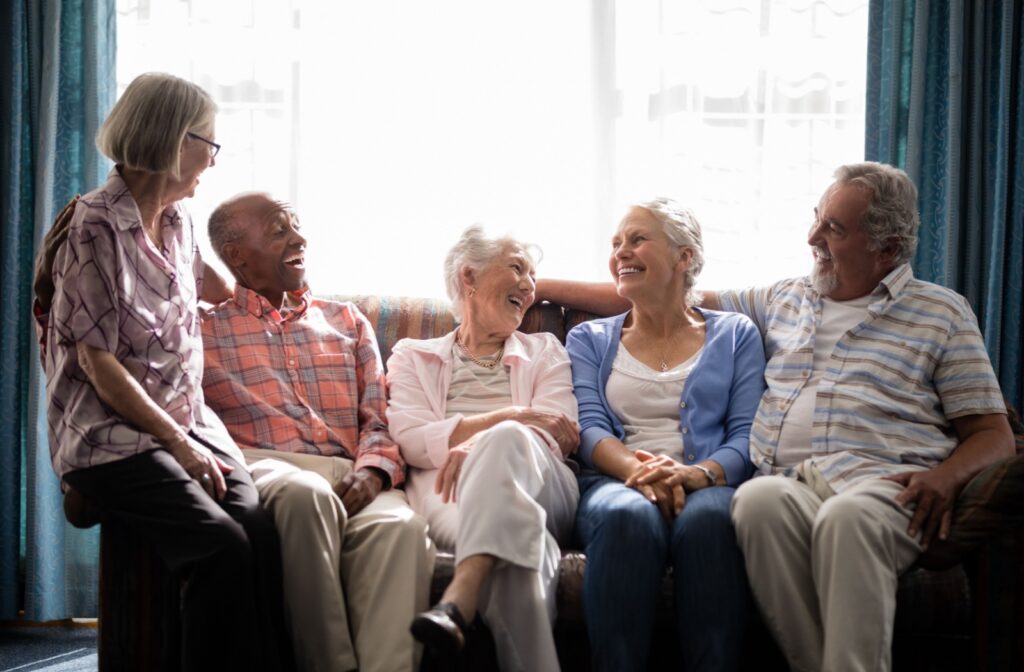 5 seniors sitting on a couch, smiling and laughing