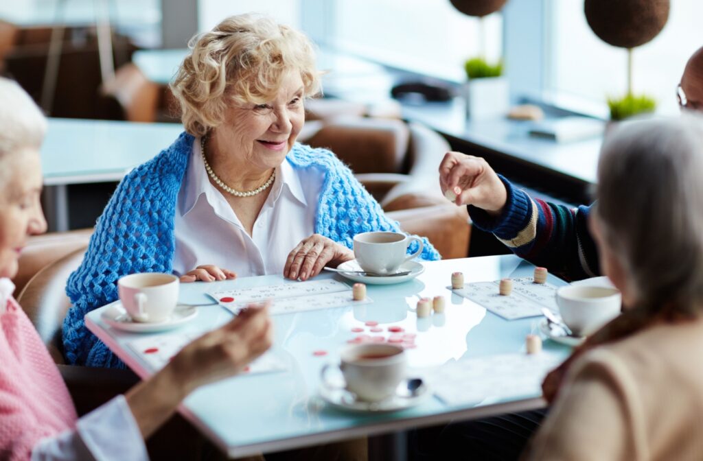 A group of older adults playing a board game together at an assisted living cafe.