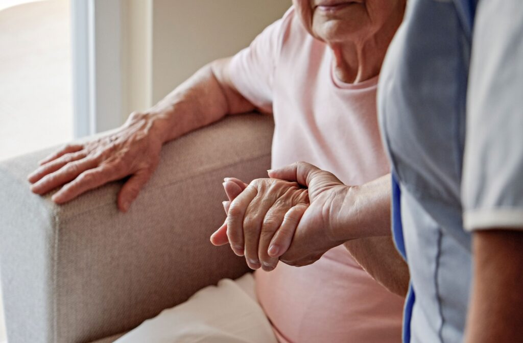 Senior woman and caregiver smiling while sitting together reflecting companionship and supportive relationships in assisted living